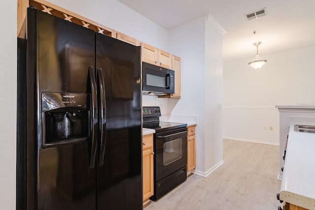 kitchen with visible vents, light wood-style floors, light countertops, black appliances, and pendant lighting