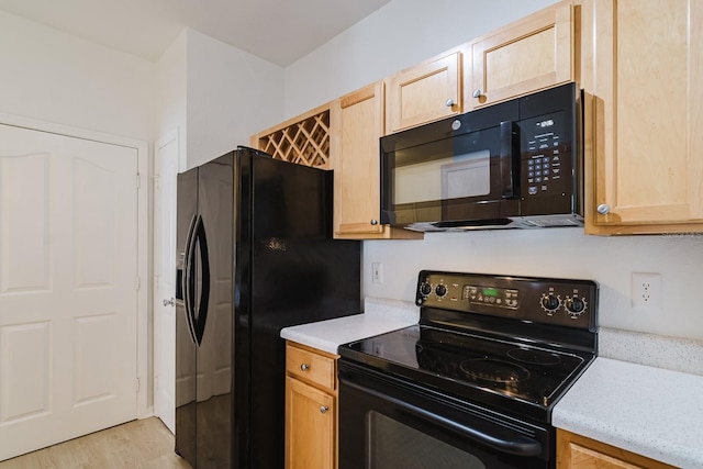 kitchen featuring black appliances, light countertops, light wood finished floors, and light brown cabinetry