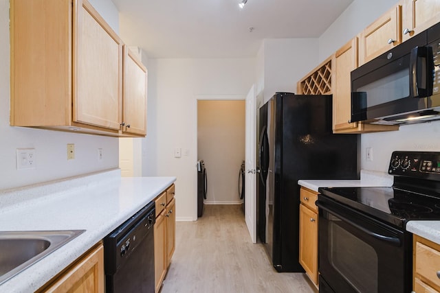 kitchen with light wood-style floors, light brown cabinets, light countertops, and black appliances