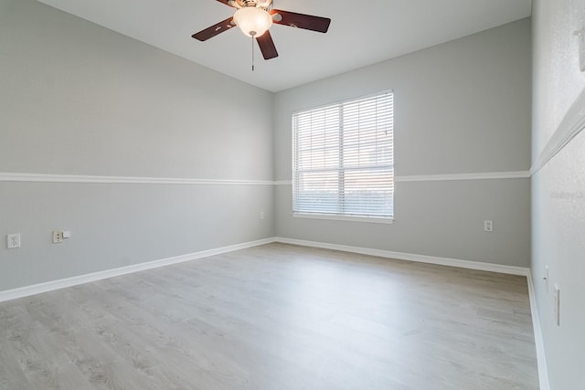 unfurnished room featuring a ceiling fan, light wood-type flooring, and baseboards