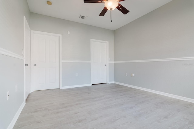 interior space featuring light wood-type flooring, baseboards, visible vents, and ceiling fan