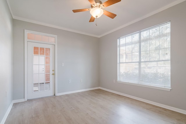 spare room featuring light wood-style floors, baseboards, ornamental molding, and a ceiling fan