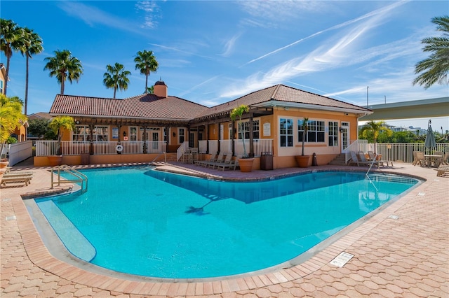 pool with a patio area and fence