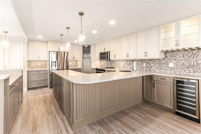 kitchen featuring wine cooler, appliances with stainless steel finishes, sink, and pendant lighting