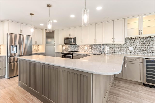 kitchen featuring wine cooler, white cabinetry, light stone counters, appliances with stainless steel finishes, and pendant lighting