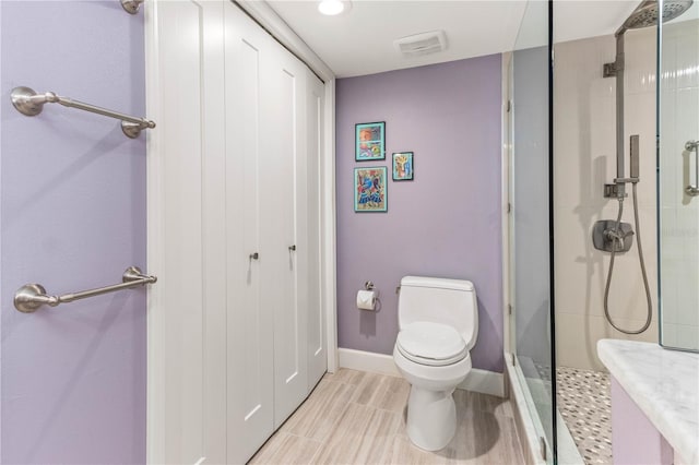 bathroom with toilet and an enclosed shower