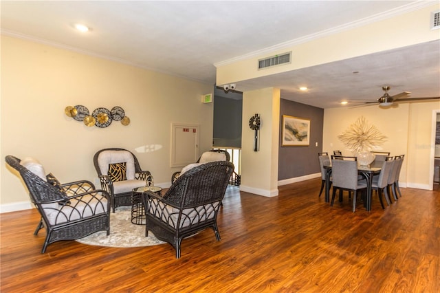 living area with dark hardwood / wood-style flooring, crown molding, and ceiling fan