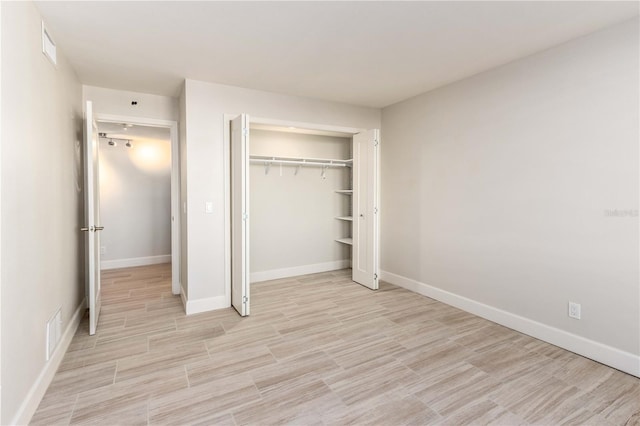 736 Island Way Unit 606, Clearwater Beach, FL 33767 - unfurnished bedroom with a closet, light wood-style flooring, and baseboards