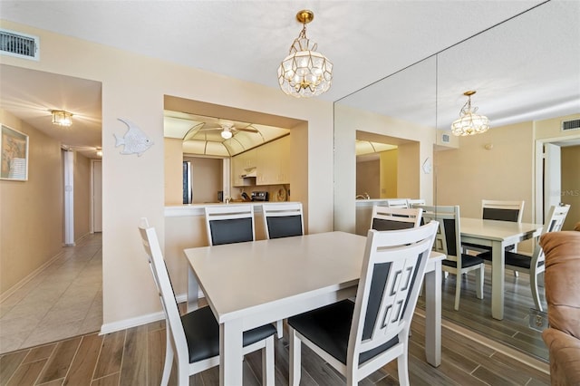 dining room with ceiling fan with notable chandelier