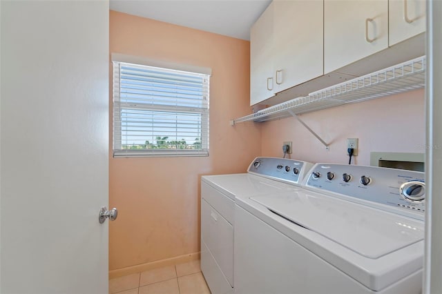 washroom featuring cabinets, washer and clothes dryer, and light tile patterned flooring