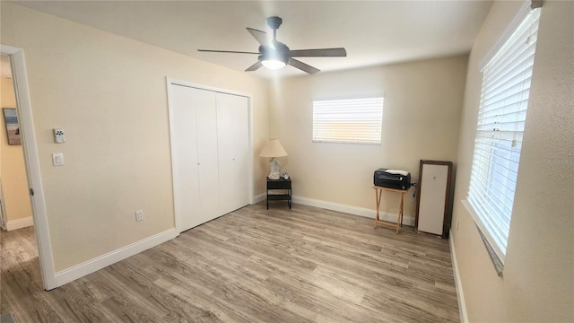 unfurnished bedroom featuring light hardwood / wood-style flooring, a closet, and ceiling fan