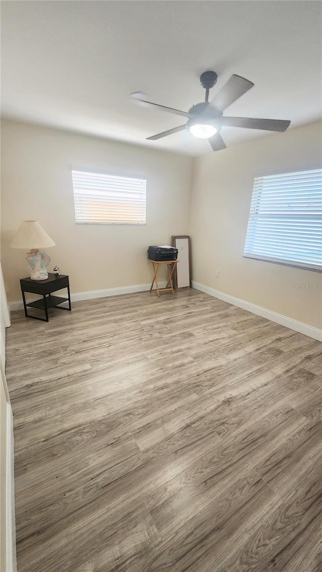 spare room with light hardwood / wood-style flooring and ceiling fan