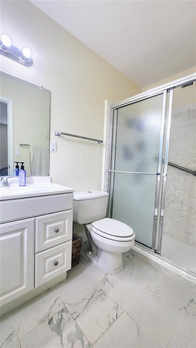 bathroom featuring vanity, toilet, and a shower with shower door