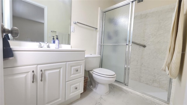 bathroom featuring vanity, a shower with shower door, and toilet