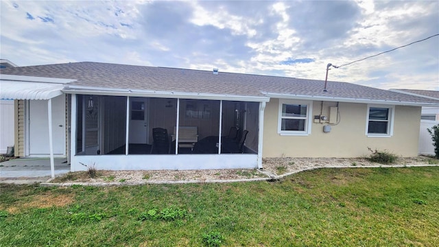 rear view of house featuring a sunroom and a yard