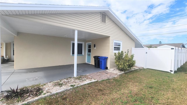 view of home's exterior with a lawn and a carport