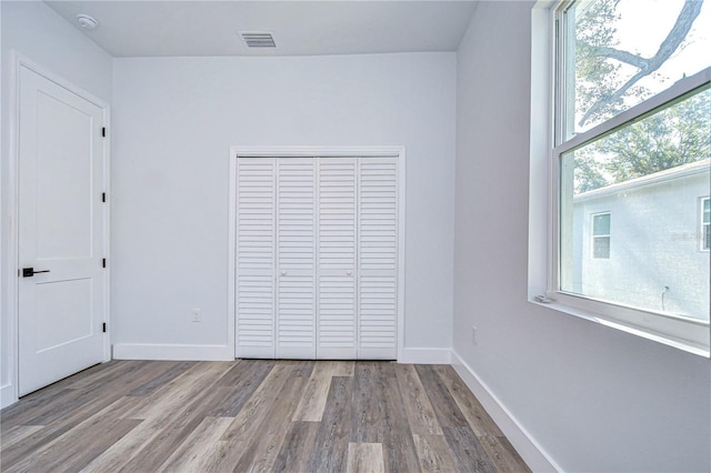 unfurnished bedroom featuring light wood-type flooring and a closet