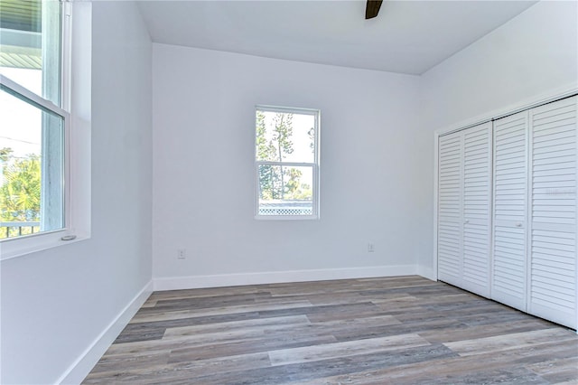 unfurnished bedroom with ceiling fan, a closet, and light hardwood / wood-style floors