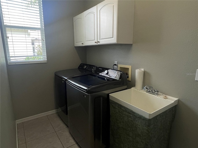 washroom featuring light tile patterned flooring, cabinets, separate washer and dryer, and sink