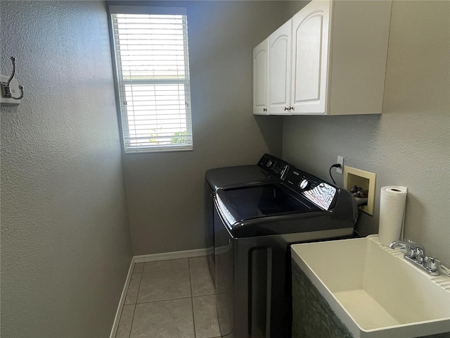 laundry area with light tile patterned flooring, cabinets, independent washer and dryer, and sink