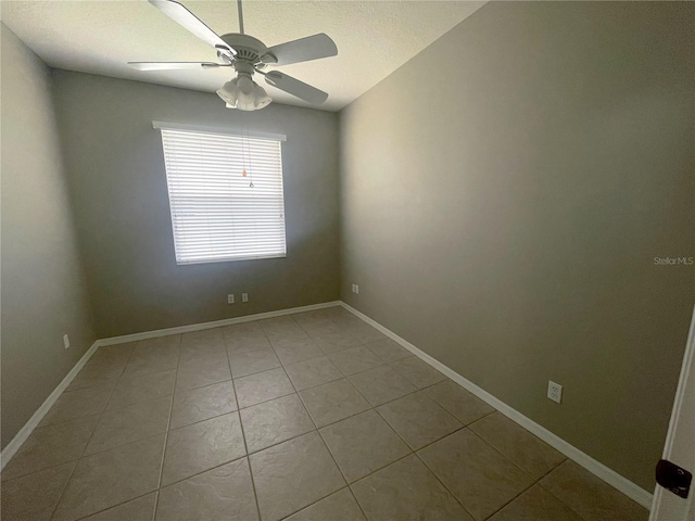 empty room with ceiling fan and tile patterned flooring