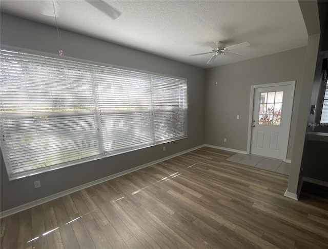 interior space with ceiling fan, dark wood-type flooring, and a textured ceiling