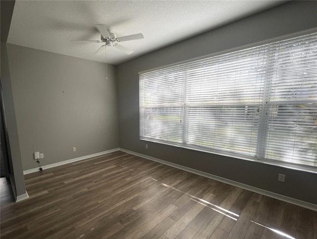 empty room with a textured ceiling, ceiling fan, and dark wood-type flooring