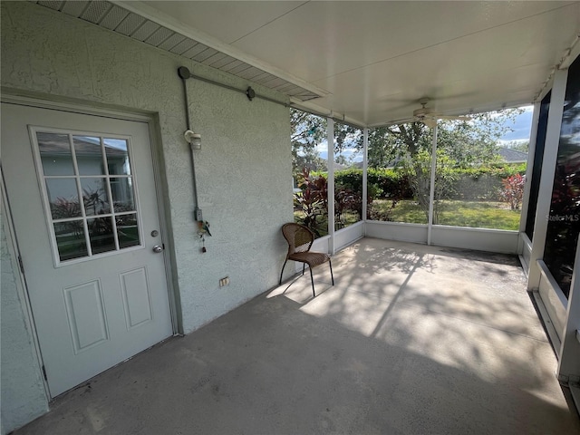 unfurnished sunroom featuring ceiling fan