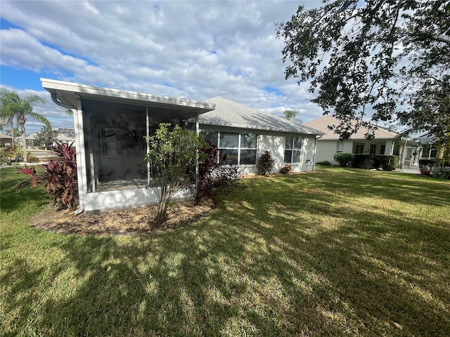 rear view of house with a sunroom and a yard