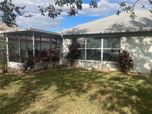 view of side of home featuring a lawn and a sunroom