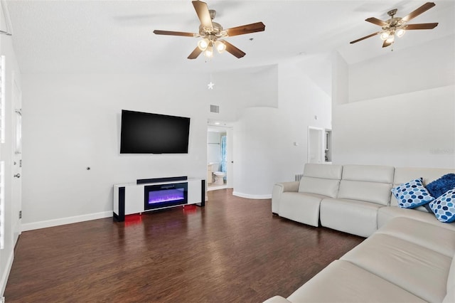 living room featuring dark hardwood / wood-style floors, high vaulted ceiling, and ceiling fan