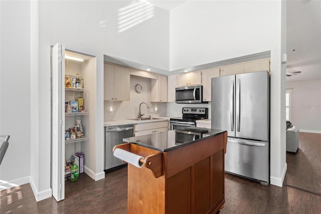 kitchen with a center island, dark wood-type flooring, a high ceiling, sink, and stainless steel appliances