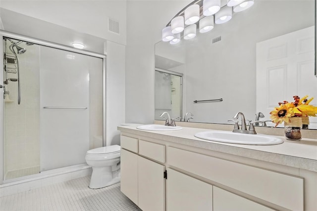 bathroom featuring tile patterned flooring, vanity, toilet, and an enclosed shower