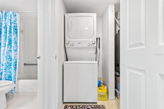 laundry area with light tile patterned flooring and stacked washing maching and dryer