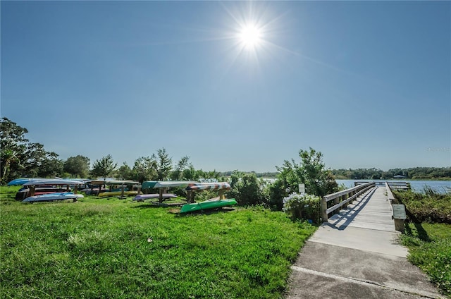 view of home's community featuring a lawn and a water view