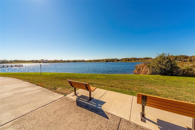 view of property's community featuring a yard and a water view