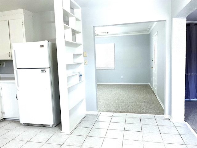 kitchen with white cabinetry, light carpet, crown molding, and white refrigerator