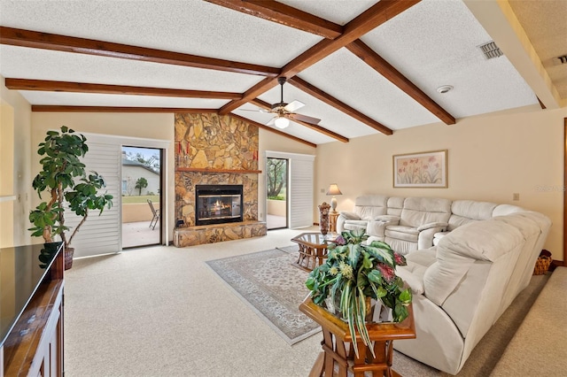 carpeted living room with a fireplace, vaulted ceiling with beams, a textured ceiling, and ceiling fan