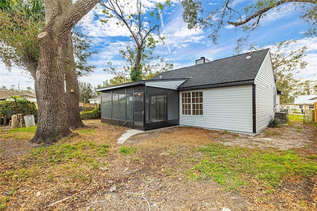 rear view of property featuring a sunroom