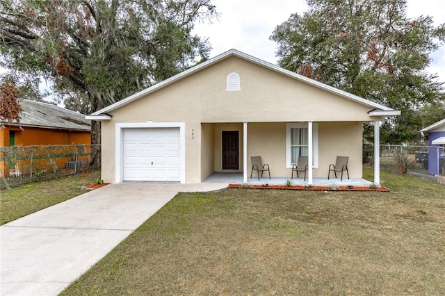 view of front of property with covered porch, a garage, and a front yard