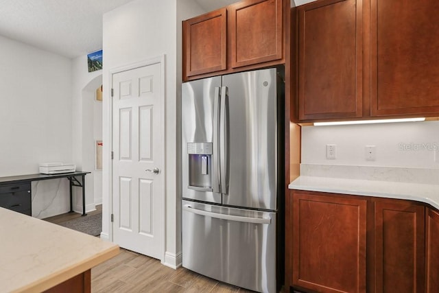 kitchen featuring stainless steel fridge with ice dispenser and light hardwood / wood-style flooring