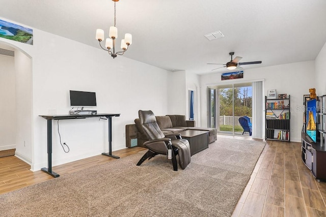 interior space with ceiling fan with notable chandelier