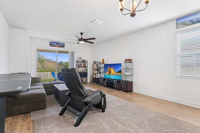 office space featuring ceiling fan with notable chandelier and hardwood / wood-style flooring