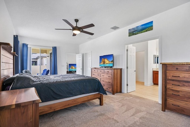 carpeted bedroom featuring ensuite bath and ceiling fan