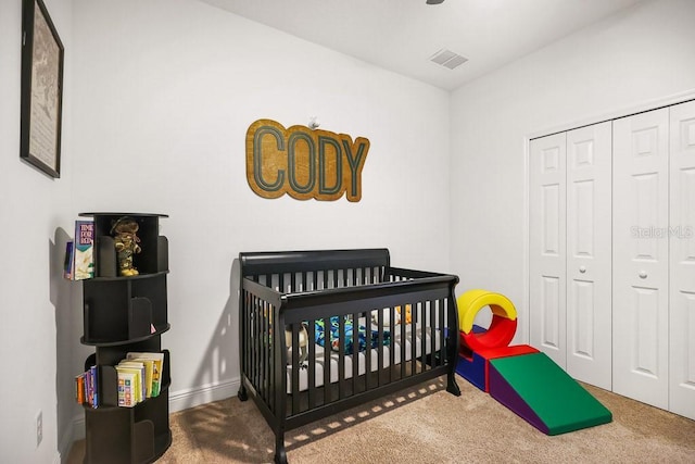 carpeted bedroom with a closet and a nursery area