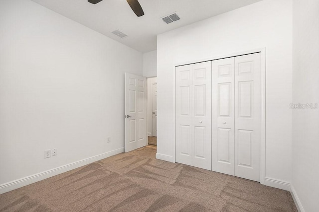 unfurnished bedroom with carpet floors, a closet, and ceiling fan