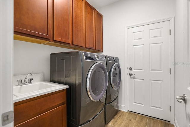 laundry room with cabinets, separate washer and dryer, and sink