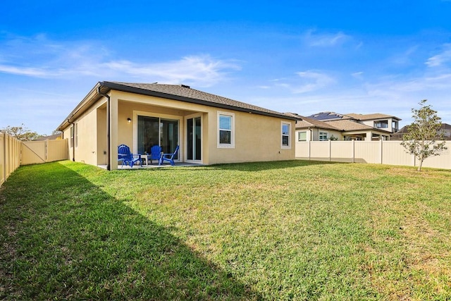 rear view of property featuring a yard