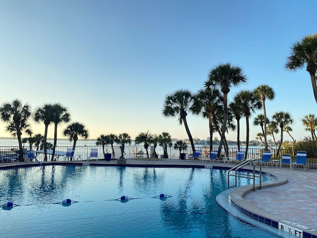 pool at dusk with a patio area