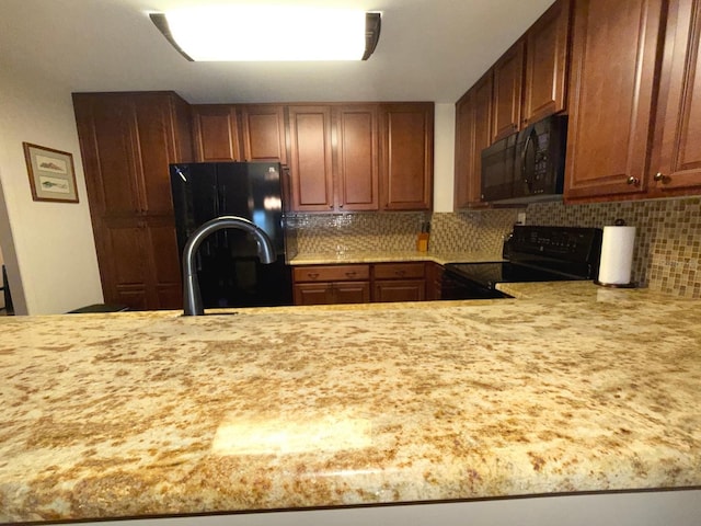 kitchen with black appliances and tasteful backsplash